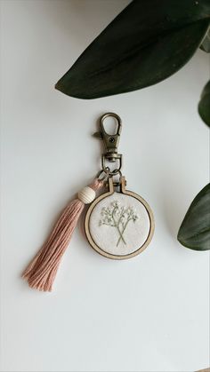 a keychain with a flower embroidered on it and a tassel hanging from the front