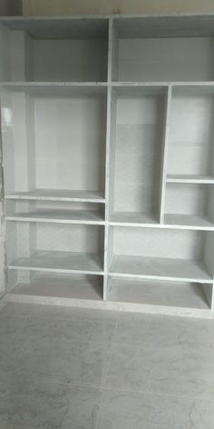 an empty room with white shelves and marble flooring in the middle, all painted white