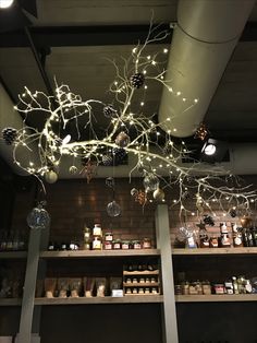 a store filled with lots of bottles and lights hanging from the ceiling above it's shelves