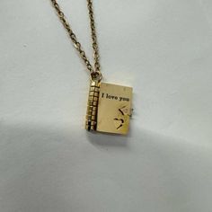 a gold necklace with an inscription that says i love you and a bird on it