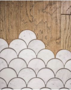 a close up of a tile floor with wood in the background