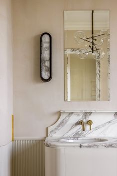 a bathroom with a marble sink and mirror on the wall next to a radiator