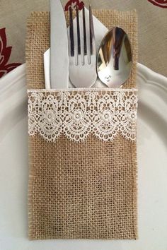 a white plate topped with a fork and knife next to a burlap napkin