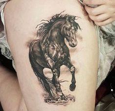 a woman's thigh with a tattoo of a horse running on the side,