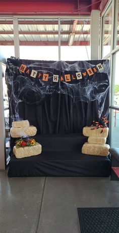 a stage set up for a halloween party with black cloth and pumpkins on it