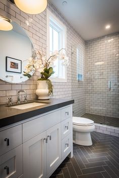 a bathroom with white cabinets and black counter tops