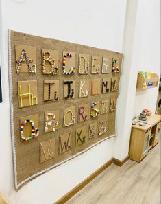 a wall hanging with letters and numbers made out of burlocks on it's side