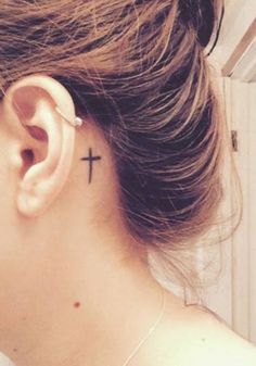 a woman with a cross tattoo on her left ear