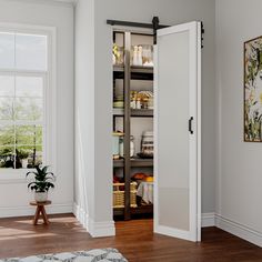 an open pantry door in the corner of a room with hardwood floors and white walls