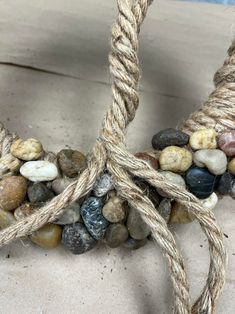 some kind of rope with rocks on it sitting on top of the ground next to another item