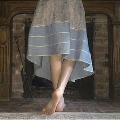 a woman standing in front of a fire place with her bare feet on the mantle