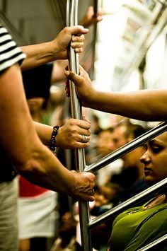 people are holding onto the bars on a subway