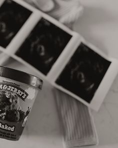 an ice cream cup sitting on top of a table next to pictures and a spoon