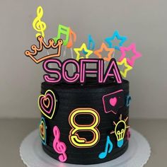 a birthday cake decorated with musical notes and neon lights for someone's 8th birthday