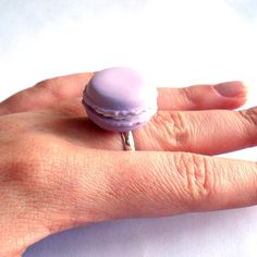 a person's hand with a ring on it and a doughnut in the middle