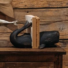 a bookend made out of wood with a bird figurine sitting on it