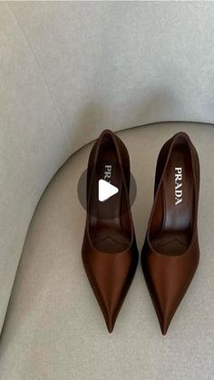 a pair of brown high heels sitting on top of a white couch next to each other