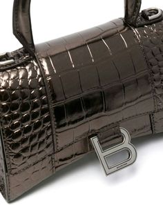 Get ready to turn heads with this stunning croc-embossed leather top-handle bag from Balenciaga. With its adjustable and detachable shoulder strap, this bag offers both style and versatility. The monogram plaque adds a touch of luxury, making it the perfect accessory for any occasion. Bronze-tone, calf leather Embossed crocodile effect Adjustable detachable shoulder strap Single circular top handle Foldover top with magnetic fastening | Balenciaga Women's Hourglass Small Leather Top-Handle Bag i Balenciaga Tote, Balenciaga Women, Planet People, Balenciaga Bag, Leather Cap, Leather Top, Embossed Leather, Womens Shoes Sneakers, Leather Tote