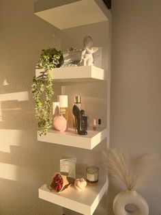 three shelves with various items on them in the corner of a room next to a wall