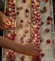 someone is decorating strawberries with candles on a sheet of snow covered baking paper