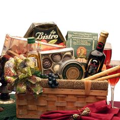 a wine and cheese gift basket on a table next to a glass of red wine