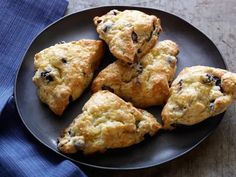 several scones on a black plate with blue napkin