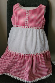 Pink gingham and white eyelet 100% cotton fabrics. Two tiers ruffle skirt. Insertion trim with pink ribbon connect bodice and skirt and the tiers. Lace trim in hem. White Ruffle Hem Dress For Picnic, Summer Gingham Dress With Tiered Skirt, Gingham Tiered Ruffle Dress, Gingham Tiered Dress With Ruffles, Plaid Cotton Tiered Dress, White Lace Trim Dress For Picnic, Cotton Gingham Dress With Lace Trim, Gingham Cotton Dress With Lace Trim, Cotton Lace Trim Dress For Picnic