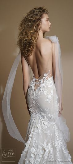 the back of a wedding dress with flowers on it, and sheer tulle veil