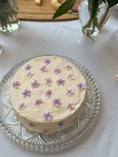 a cake on a glass plate with purple flowers