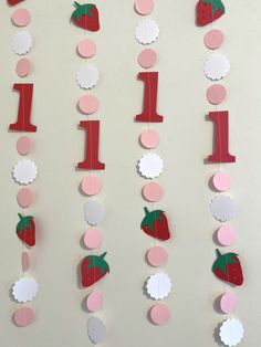 the number one is made out of paper with strawberries and other items hanging from it