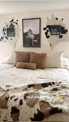 a bed with two cow prints on the wall above it