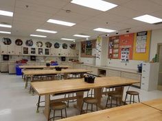 an empty classroom with desks and chairs in the middle, several pictures on the wall