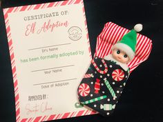 an elf's stocking is next to a certificate