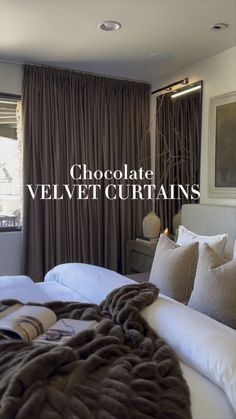 chocolate velvet curtains in a bedroom next to a bed with pillows and blankets on it