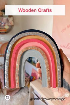 a person holding up some wooden crafts with rainbows on them and the words wooden crafts above it