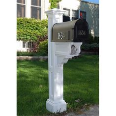 a white mailbox sitting in the grass next to a house