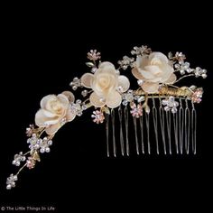 a hair comb with flowers and leaves on it's headpiece, against a black background