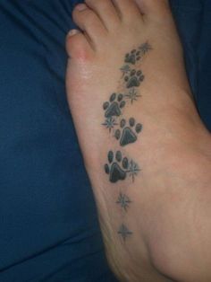 a person has a paw print tattoo on their foot and it looks like they are going to get inked