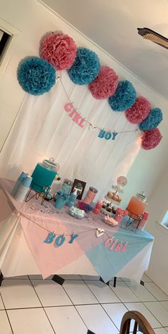 a baby shower table with tissue pom poms on the top and decorations around it