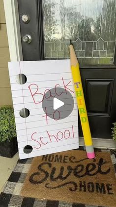 a door mat with a pencil and paper on it next to a sign that says back to school