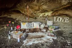 an animal skin rug with flowers and candles on it next to a sign that says love