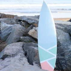 a surfboard sitting on top of a pile of rocks