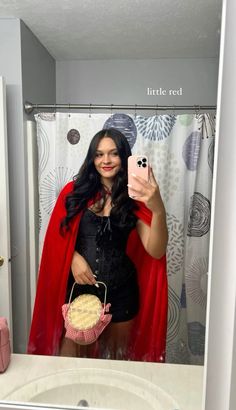 a woman taking a selfie in a bathroom mirror with a cupcake on the counter