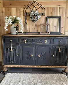 an old dresser is painted black and decorated with flowers