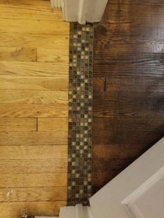 a bathroom with wood flooring and tile on the walls, along with a toilet