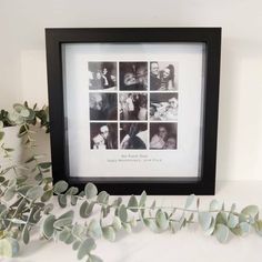 a black and white photo frame sitting on top of a table next to eucalyptus leaves