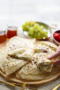 a plate with some pita bread on it next to grapes and ketchup