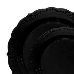 four black plates with ornate designs on the rims, all in different shapes and sizes