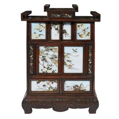 an old wooden cabinet with glass doors and flowers on the front, inlaid to it's sides