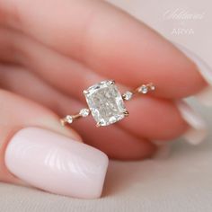 a woman's hand holding an engagement ring with a large diamond in the middle